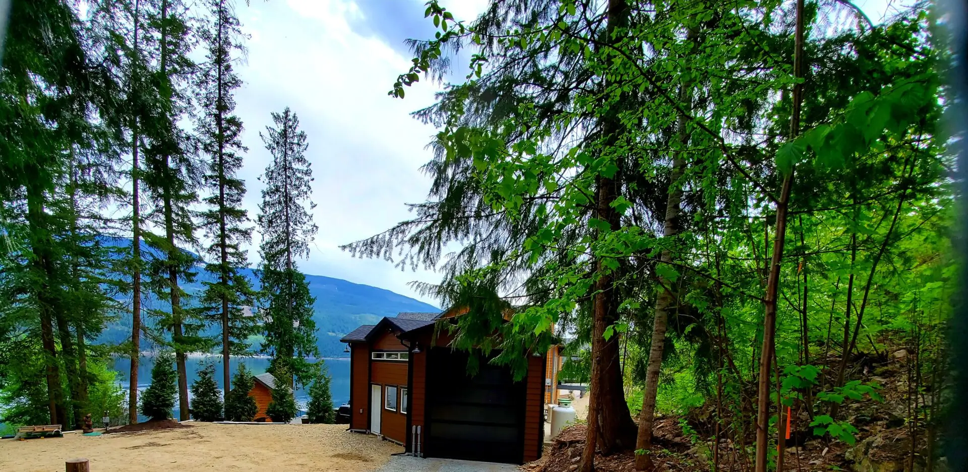 A garage with trees and mountains in the background.